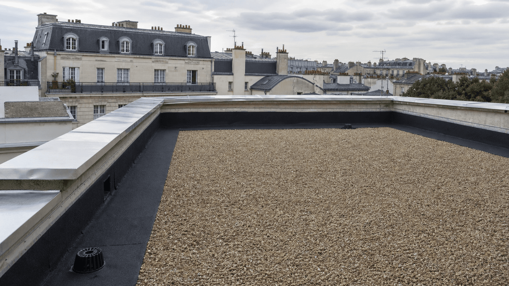 Vue réaliste d'une toiture-terrasse de copropriété rénovée avec membrane bitumineuse à Versailles